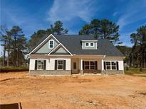 New construction home featuring a welcoming front porch, gray roof, and black shutters on a spacious lot ready for landscaping at 1471 Stephens View Dr, Loganville, GA 30052