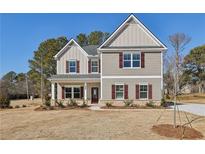 Charming two-story home with red shutters, neutral siding, covered porch and freshly landscaped front yard at 3603 Squires Park Ln, Loganville, GA 30052