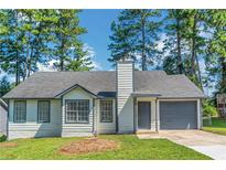 Charming single-Gathering home featuring a well-maintained lawn and attached garage at 6304 Marbut Farms Ln, Lithonia, GA 30058