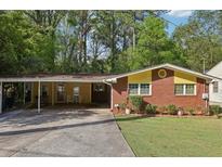 Charming brick home featuring a covered carport and a well-manicured lawn at 2081 Beecher Sw Rd, Atlanta, GA 30311