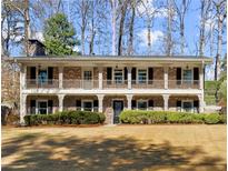Two story brick home with a large front yard and large porch spanning the entire front of the home at 2344 Sagamore Hills Dr, Decatur, GA 30033
