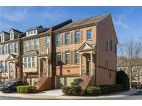 Charming brick townhome with manicured landscaping and inviting front entrance on a sunny day at 24 Rockland Pl, Decatur, GA 30030