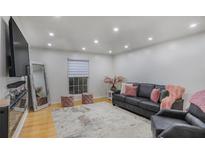 Bright living room featuring recessed lighting, hardwood floors, and a stylish gray sofa with pink accents at 5600 Kingsport Dr, Atlanta, GA 30342