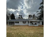 Charming one-story home with gray siding, covered parking, and a welcoming front porch at 3784 Robinson Ne Rd, Marietta, GA 30068