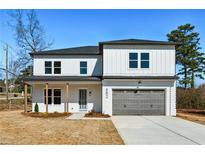 Two-story home featuring a modern design, white brick, gray garage door, and a well-lit entry at 482 Majestic Oaks Pl, Smyrna, GA 30082