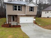 Two-story home with a brick and vinyl exterior, attached garage, and newly landscaped front yard at 129 Creek Crossing Ln, Temple, GA 30179