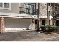 Townhome featuring an attached garage, brick accents, private balcony, and neutral exterior paint at 4254 River Green Nw Dr # 611, Atlanta, GA 30327