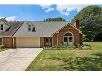 Charming brick home featuring a well-manicured lawn and attached two-car garage at 555 Brickleberry Ln, Roswell, GA 30075