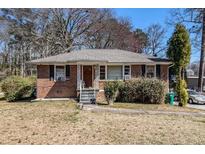 Charming brick home with a cozy front porch and well-maintained landscaping at 1210 Stoneybrook Rd, Forest Park, GA 30297