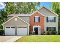 Charming two-story home with a well-manicured lawn and an attached two-car garage at 4110 Ridgebrook Bnd, Cumming, GA 30028