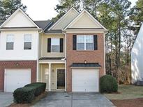 Charming townhome with a brick and siding facade, featuring a one-car garage and manicured landscaping at 2939 Greyhawk Ln, Cumming, GA 30040