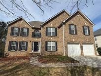 Charming two-story brick home featuring black shutters and a two-car garage at 675 Paper Creek Dr, Lawrenceville, GA 30046