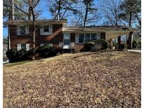 Charming brick home with a covered carport and mature landscaping in a quiet neighborhood at 2977 Appling Dr, Atlanta, GA 30341