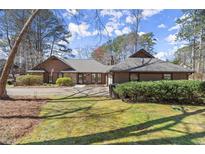 Charming single-story home with well-maintained landscaping, large driveway, and classic design elements at 3093 Brookshire Way, Duluth, GA 30096