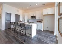 Modern kitchen featuring white cabinets, stainless steel appliances, and a breakfast bar with seating at 542 Sawnee Village Blvd # D69, Cumming, GA 30040