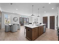 Bright, open-concept kitchen with a center island, modern appliances, and dining area at 542 Sawnee Village Blvd # D69, Cumming, GA 30040