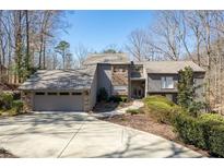 Charming home featuring a stone facade, attached garage, and beautiful landscaping at 8700 The Fifth Grn, Atlanta, GA 30350