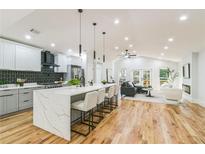 Open-concept kitchen featuring a large island with seating and pendant lighting next to a cozy living room at 842 Laurelmont Sw Dr, Atlanta, GA 30311