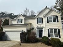 Charming two-story home featuring a black front door, attached garage, and well-maintained landscaping at 2845 White Blossom Ln, Suwanee, GA 30024