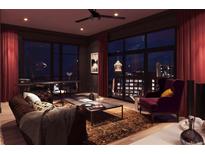 Inviting living room with dark accents, floor-to-ceiling windows, and stylish furnishings at 567 Ponce De Leon Ne Ave # 502, Atlanta, GA 30308