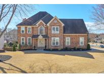 Stunning two-story brick home with a well-manicured lawn and beautiful architectural details at 305 Hembree Grove Trce, Roswell, GA 30076