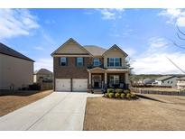 Charming two-story brick home with well-manicured front yard and a two-car garage at 2880 Ridge Manor Dr, Dacula, GA 30019