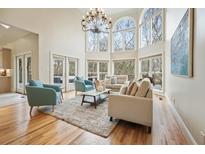 Bright living room with large windows, hardwood floors, and modern furnishings under a chandelier at 2938 Summitop Ne Rd, Marietta, GA 30066