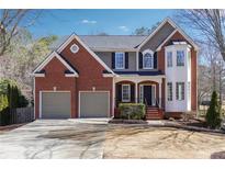 Beautiful two-story brick home featuring an attached two-car garage and well-manicured landscaping at 5060 Winship Ct, Alpharetta, GA 30009
