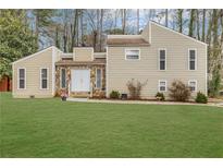 Inviting two-story home featuring stone accents, a well-manicured lawn, and mature trees at 2540 Alberta Ln, Marietta, GA 30062