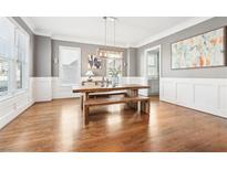 Inviting dining room with hardwood floors, decorative wall paneling, and modern light fixtures at 2685 Grady Se St, Smyrna, GA 30080