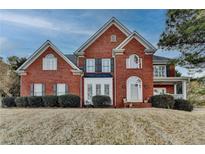 Charming two-story brick home with manicured lawn, dormer windows and covered front porch at 2095 Tribble Walk Dr, Lawrenceville, GA 30045