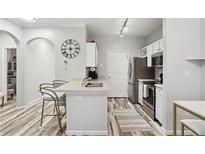 Cozy kitchen featuring an island with counter seating, stainless steel appliances, and light wood-look flooring at 4333 Dunwoody Park # 1109, Atlanta, GA 30338