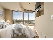Bright bedroom boasts a large window with stunning city views and a wall-mounted television at 361 17Th Nw St # 1021, Atlanta, GA 30363