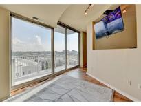 Bright living room featuring floor-to-ceiling windows with city views and a wall-mounted television at 361 17Th Nw St # 1021, Atlanta, GA 30363