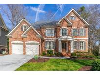 Charming two-story brick home with a well-manicured lawn and attached two-car garage at 730 Glenferry Trl, Atlanta, GA 30328