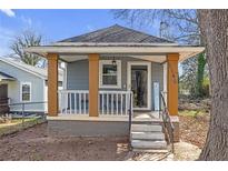 Charming bungalow with a cozy front porch, painted in inviting gray tones, and well-maintained front yard at 1146 Sims Sw St, Atlanta, GA 30310