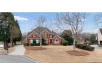 Beautiful two-story brick home with a manicured front yard and a long driveway at 426 Lakestone Dr, Suwanee, GA 30024