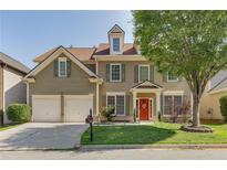 Charming two-story home with a well-manicured lawn, a two-car garage, and a welcoming red front door at 730 Pear Grove Pl, Marietta, GA 30066