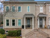 Charming townhome with a neutral stucco facade, brick accents, and a welcoming entrance at 1477 Village Park Ne Ct, Atlanta, GA 30319