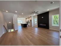 Open-concept living space featuring an electric fireplace, hardwood floors and kitchen island at 1923 Cassia Aly, Kennesaw, GA 30144
