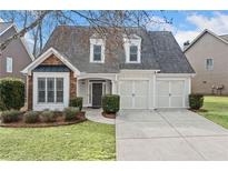 Charming traditional home featuring a manicured lawn, two-car garage, and brick accents at 1168 Christiana Xing, Lawrenceville, GA 30043