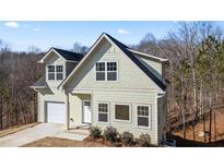 Charming two-story home with a light green exterior and a neatly attached single-car garage at 3185 Tackett Rd, Douglasville, GA 30135