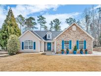 Charming ranch-style home with stone accents, blue shutters, and manicured landscaping at 1020 Adie Cv, Mcdonough, GA 30253
