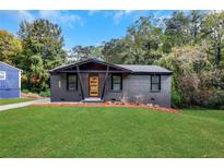 Charming brick home with a well-manicured lawn and modern wood door, providing excellent curb appeal at 3850 Crosby Nw Dr, Atlanta, GA 30331
