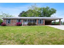 Charming single-story brick home with a carport and front yard landscaping at 3894 Summit Dr, Douglasville, GA 30135