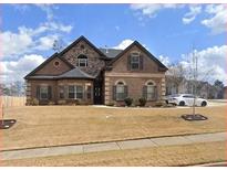 Charming brick home featuring a manicured front lawn and a two-car garage at 3492 Maple Hill Rd, Lithonia, GA 30038