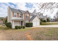 Charming two-story home featuring stone accents, neutral siding, an attached two-car garage, and manicured landscaping at 4728 Sedum Way, Atlanta, GA 30349
