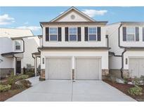 Charming townhome featuring a two-car garage, white siding, and black shutters, offering modern curb appeal at 3545 Bexton Dr, Duluth, GA 30097