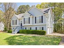 Charming two-story home with manicured lawn, three car garage, and elegant gray siding at 169 Bethnal Way, Douglasville, GA 30134