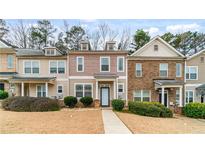 Charming townhouse showcasing a landscaped front yard and inviting entrance at 6327 Ellenwood Dr, Rex, GA 30273